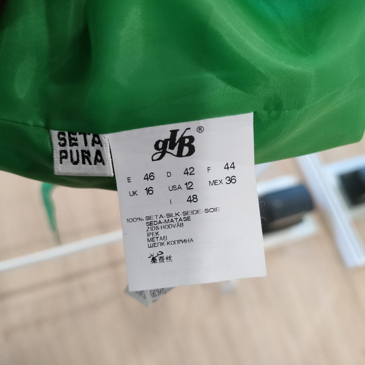 Clothing label with brand name and size information on a green fabric background