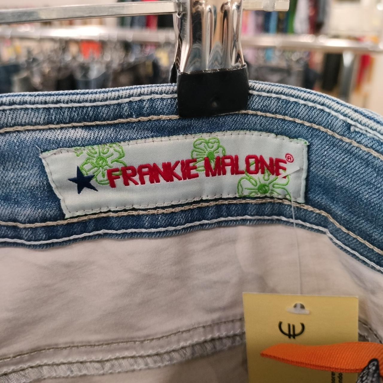 Closeup of FRANKIE MALONE denim jeans label with stitched details and price tag