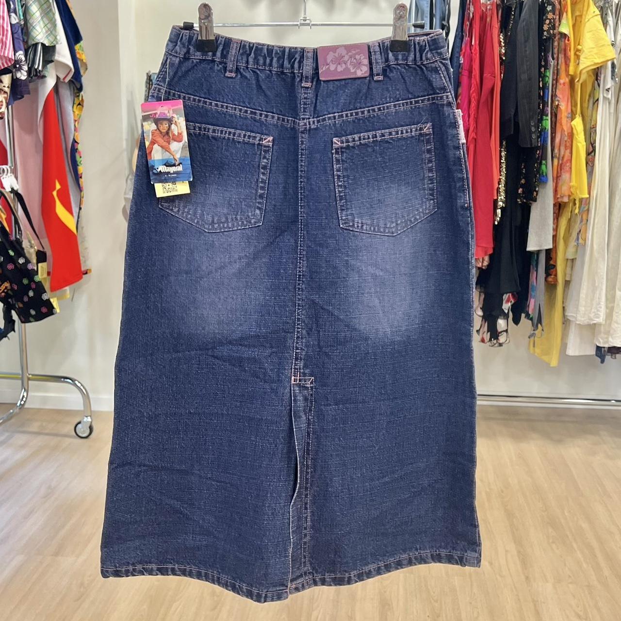 Blue denim skirt on a hanger with a clothing rack in the background