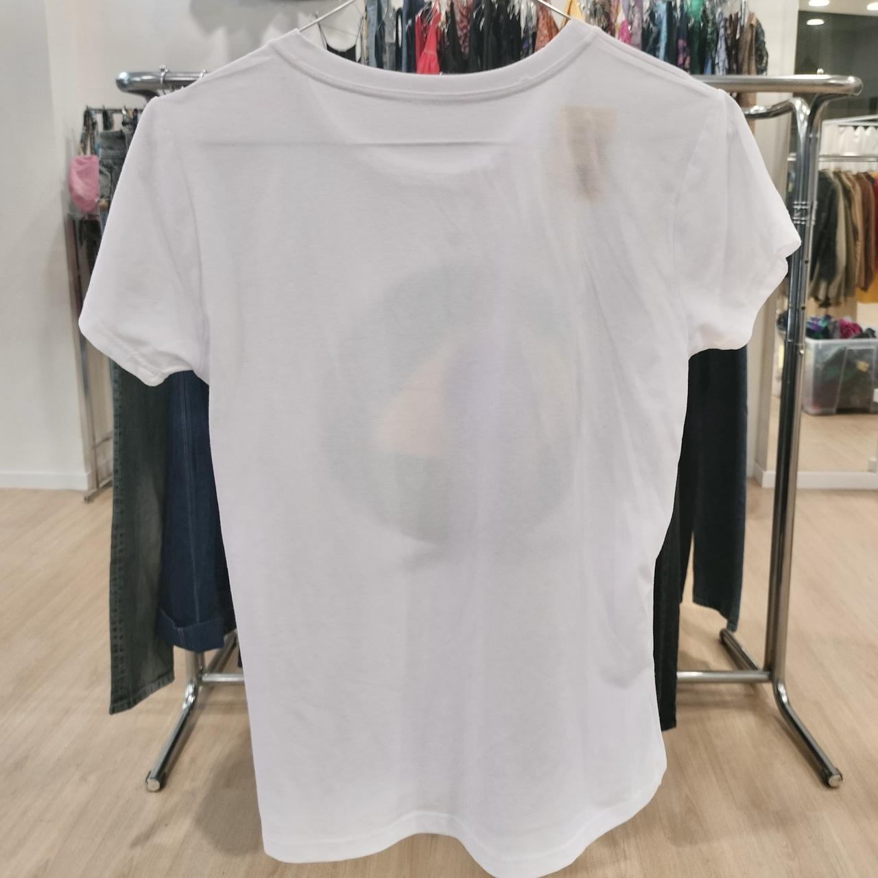 White short sleeve t-shirt on hanger in second hand fashion store