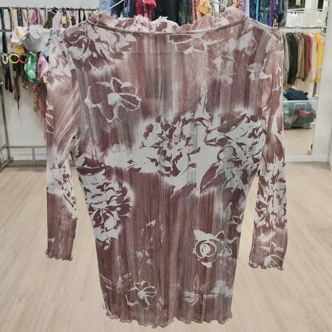 Sheer floral long sleeve blouse with brown and white pattern in a vintage clothing store