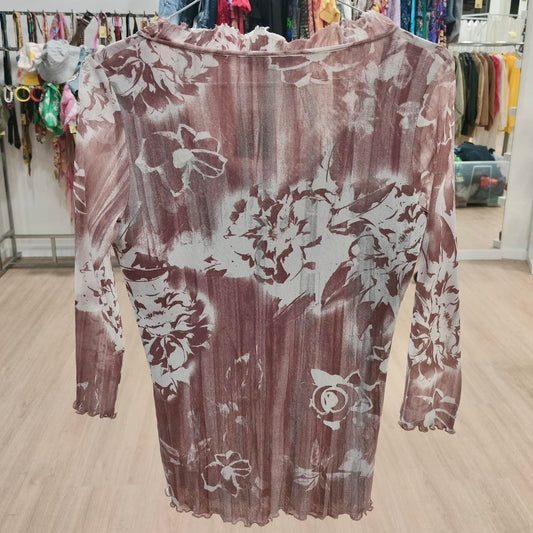 Sheer floral long sleeve blouse with brown and white pattern in a vintage clothing store