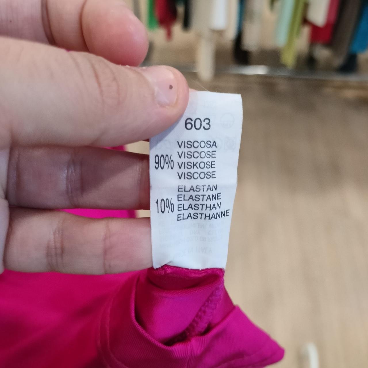 Clothing label on a pink garment with text details