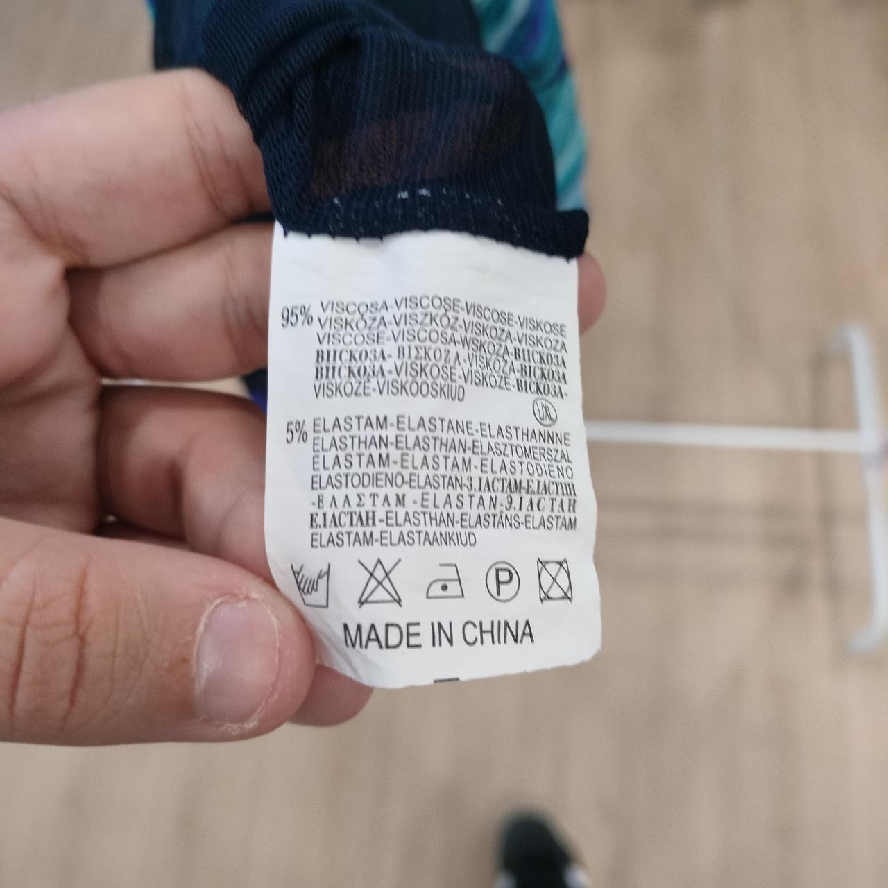 Clothing care label showing 95% viscose, 5% elastane, washing symbols, made in China