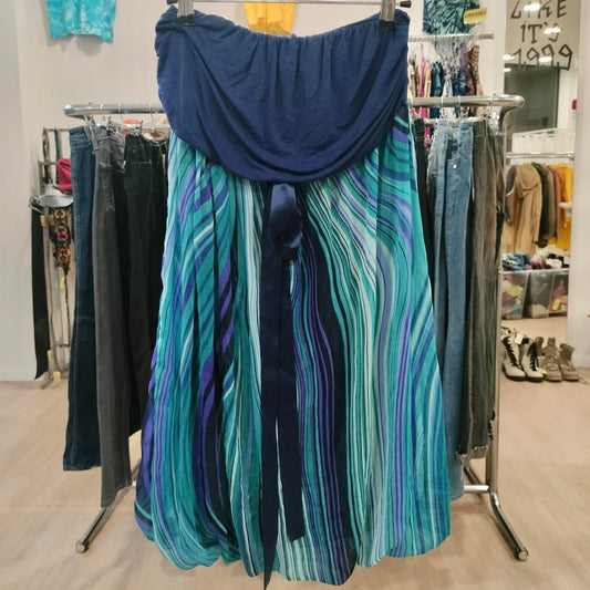 Blue and teal pleated midi skirt with striped pattern hanging in a sustainable fashion store