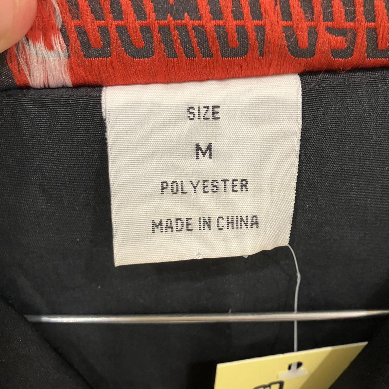 Clothing label with size, material, and origin information on a garment