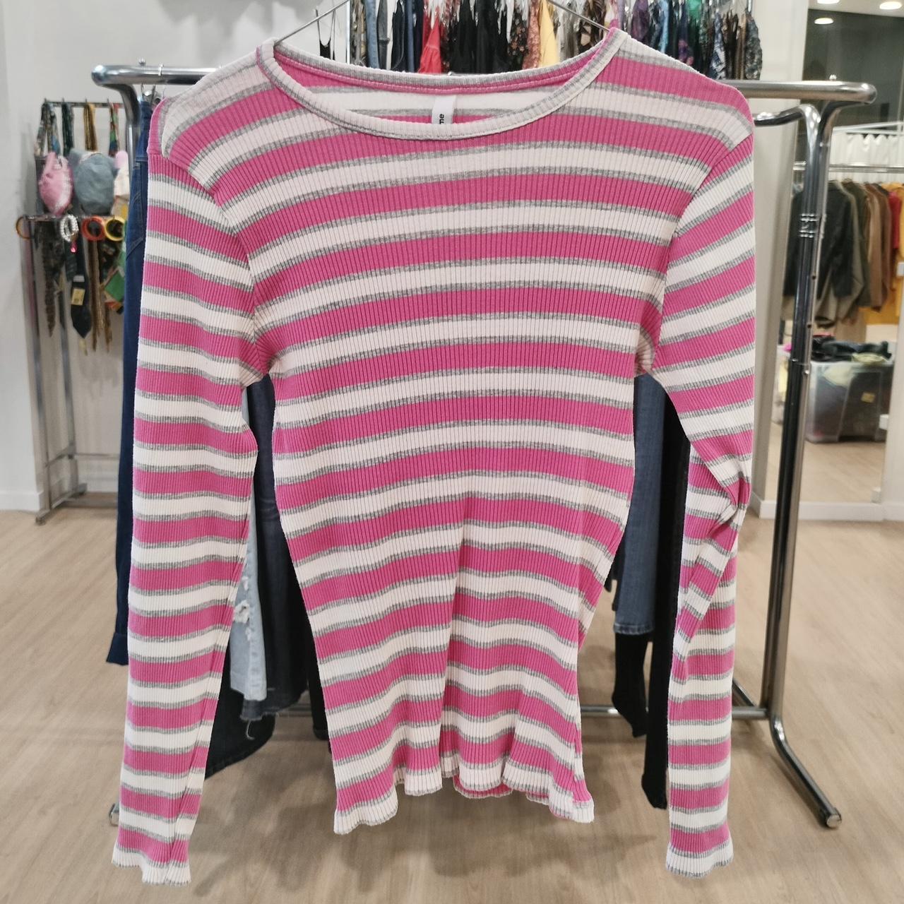 Pink and white long sleeve ribbed striped top on hanger in second hand fashion store