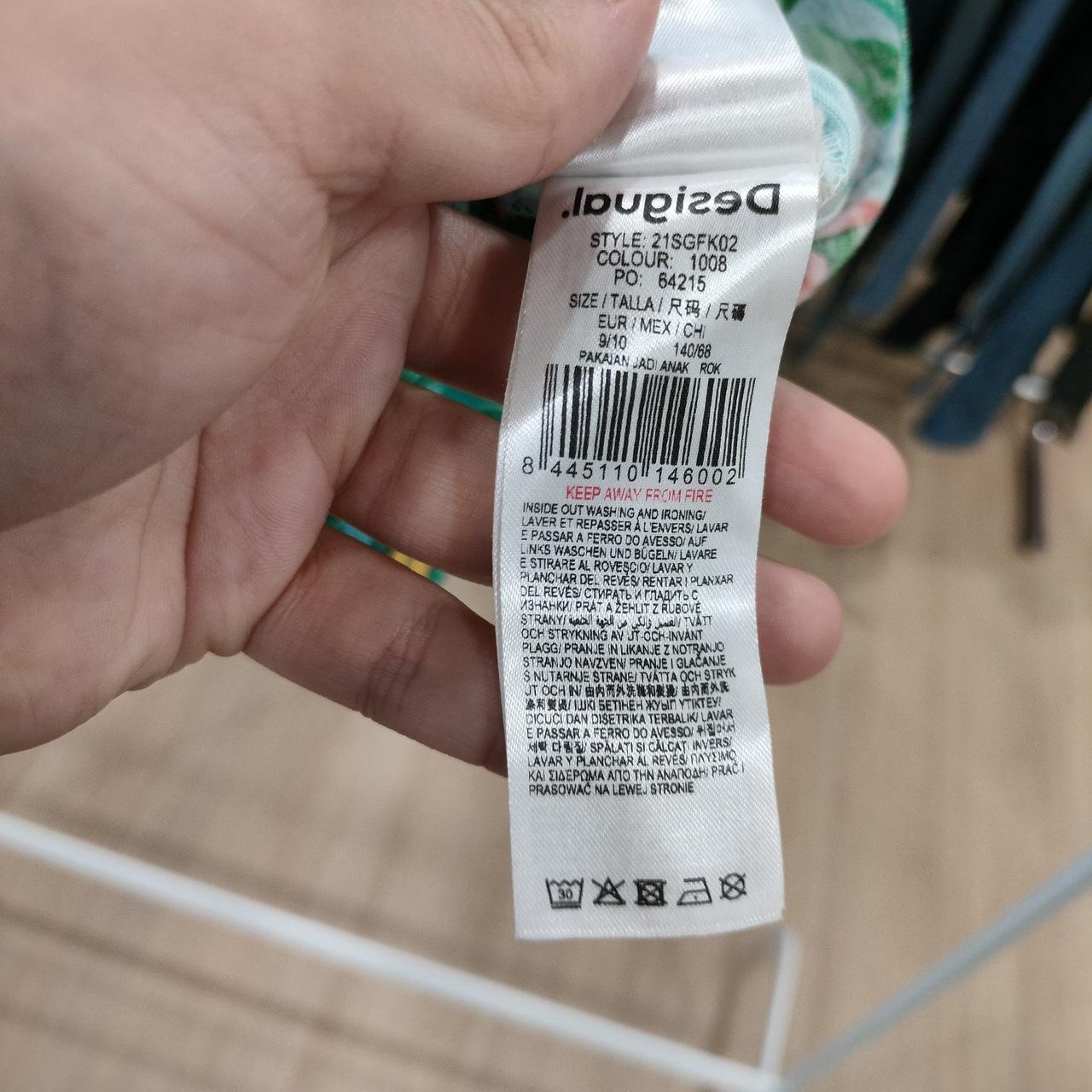 Close-up of a product label held by a hand on a blurred background