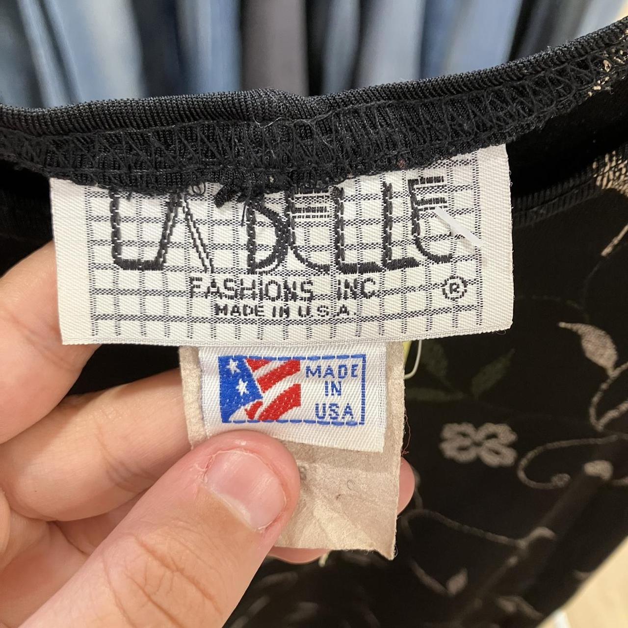 Clothing tag with 'LaBelle Fashions Inc.' and 'Made in USA' label held by a hand