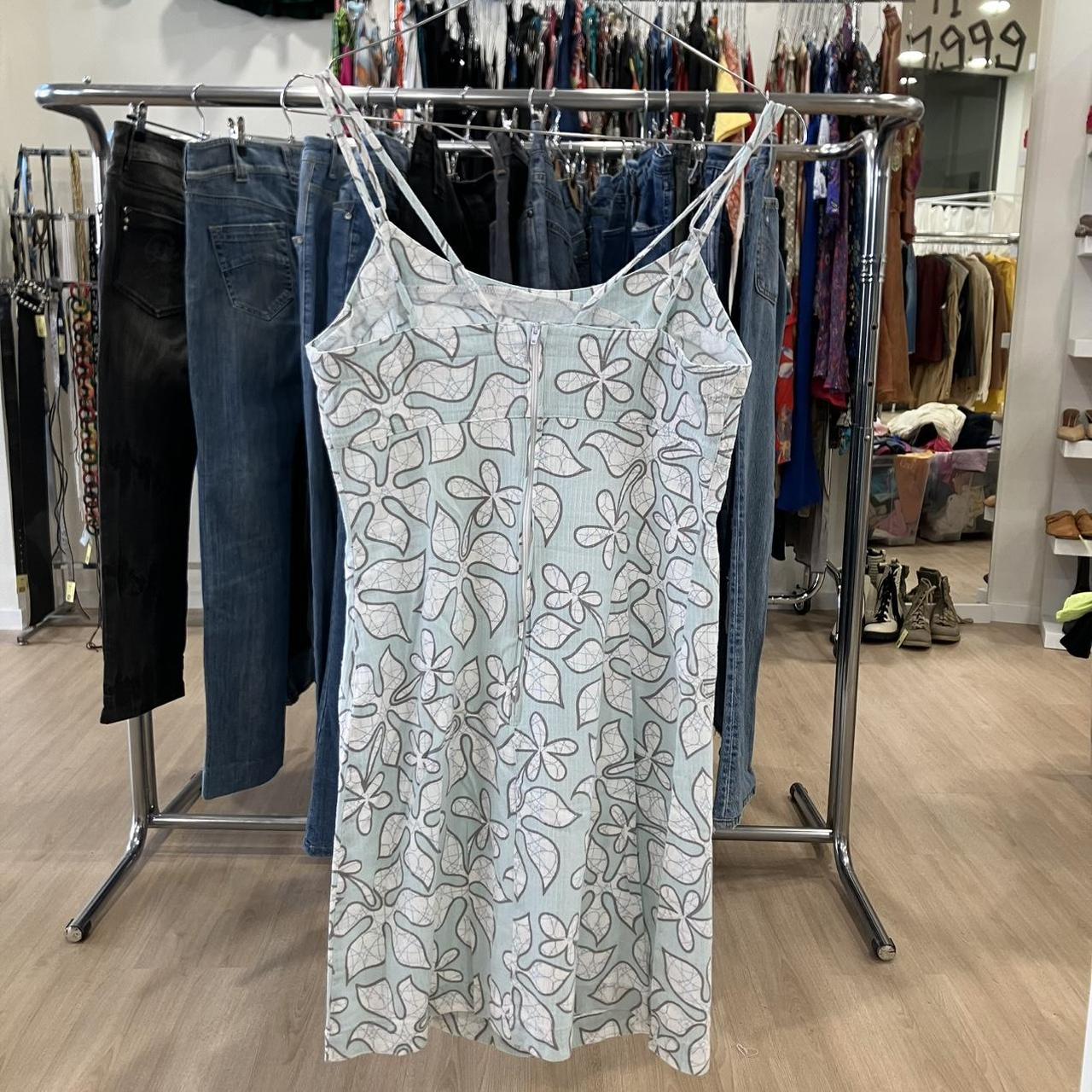 Light blue floral-patterned dress hanging on a rack in a store setting
