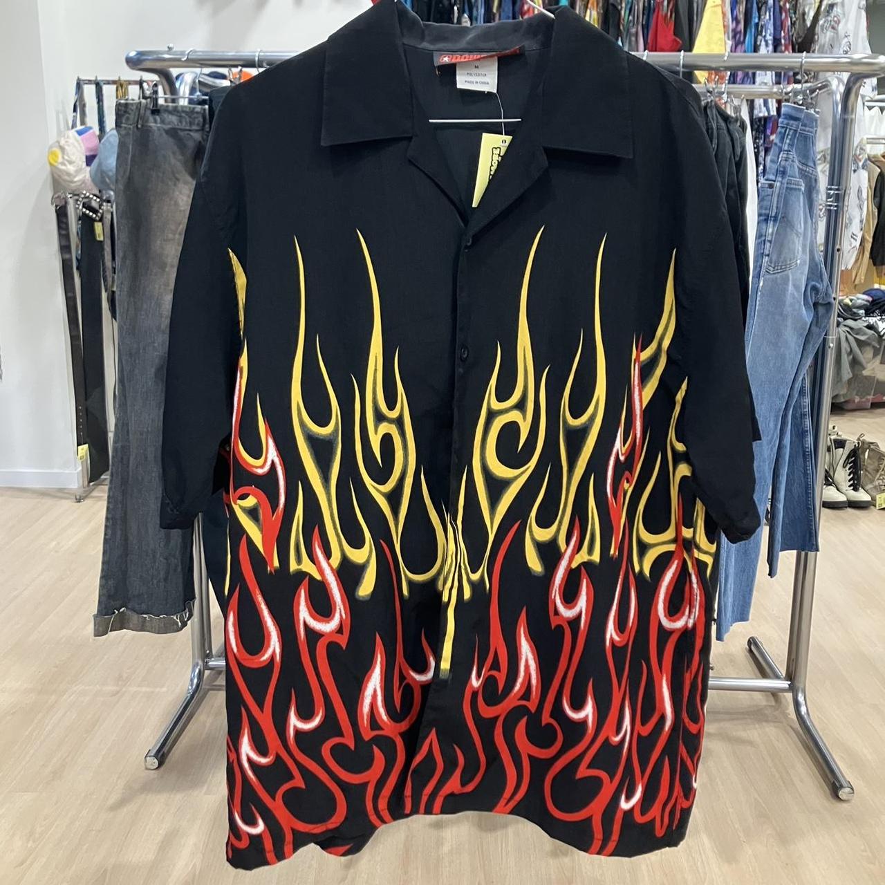 Black shirt with red and yellow flame design on a clothing rack