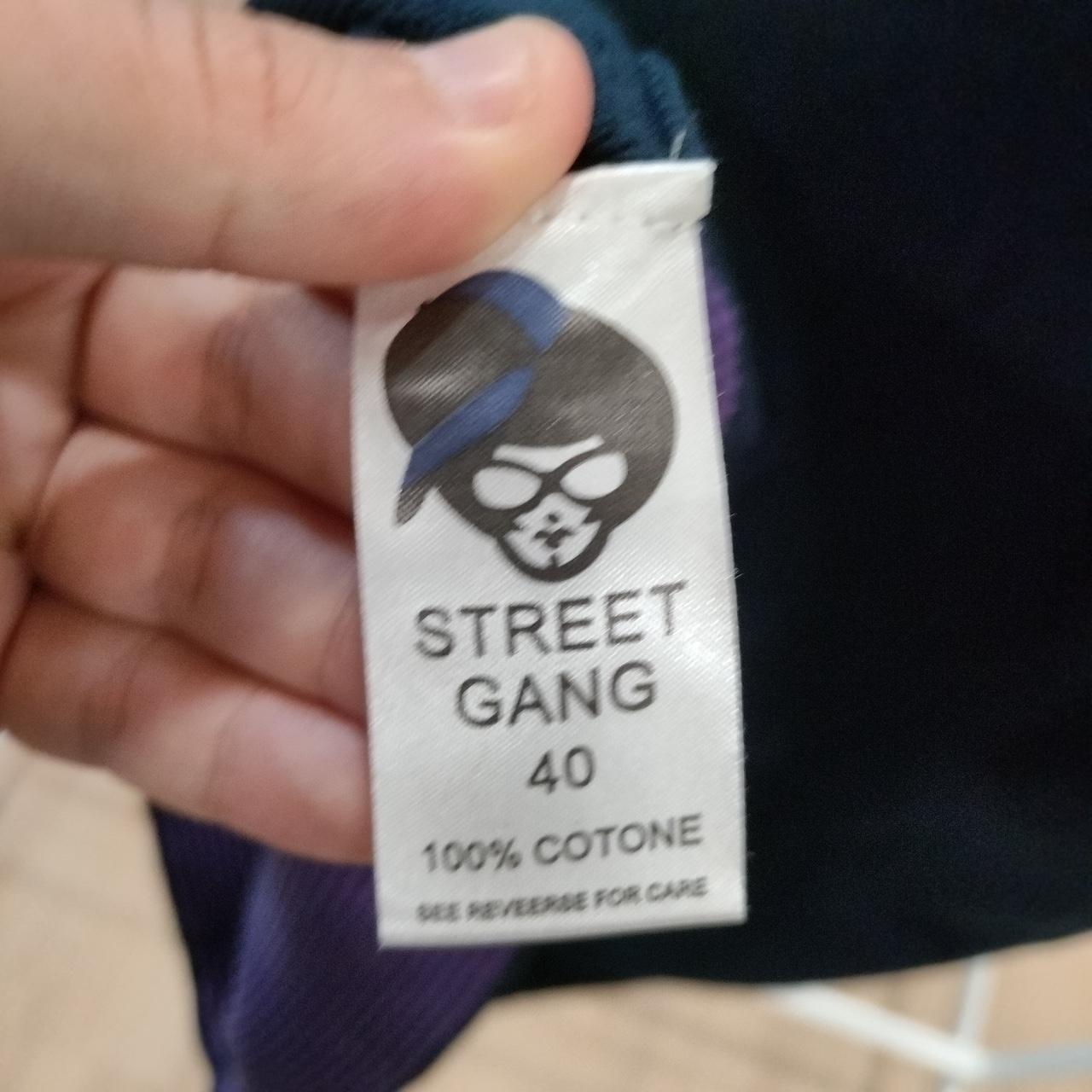 Street Gang clothing label with size 40, 100% cotton, held by a hand