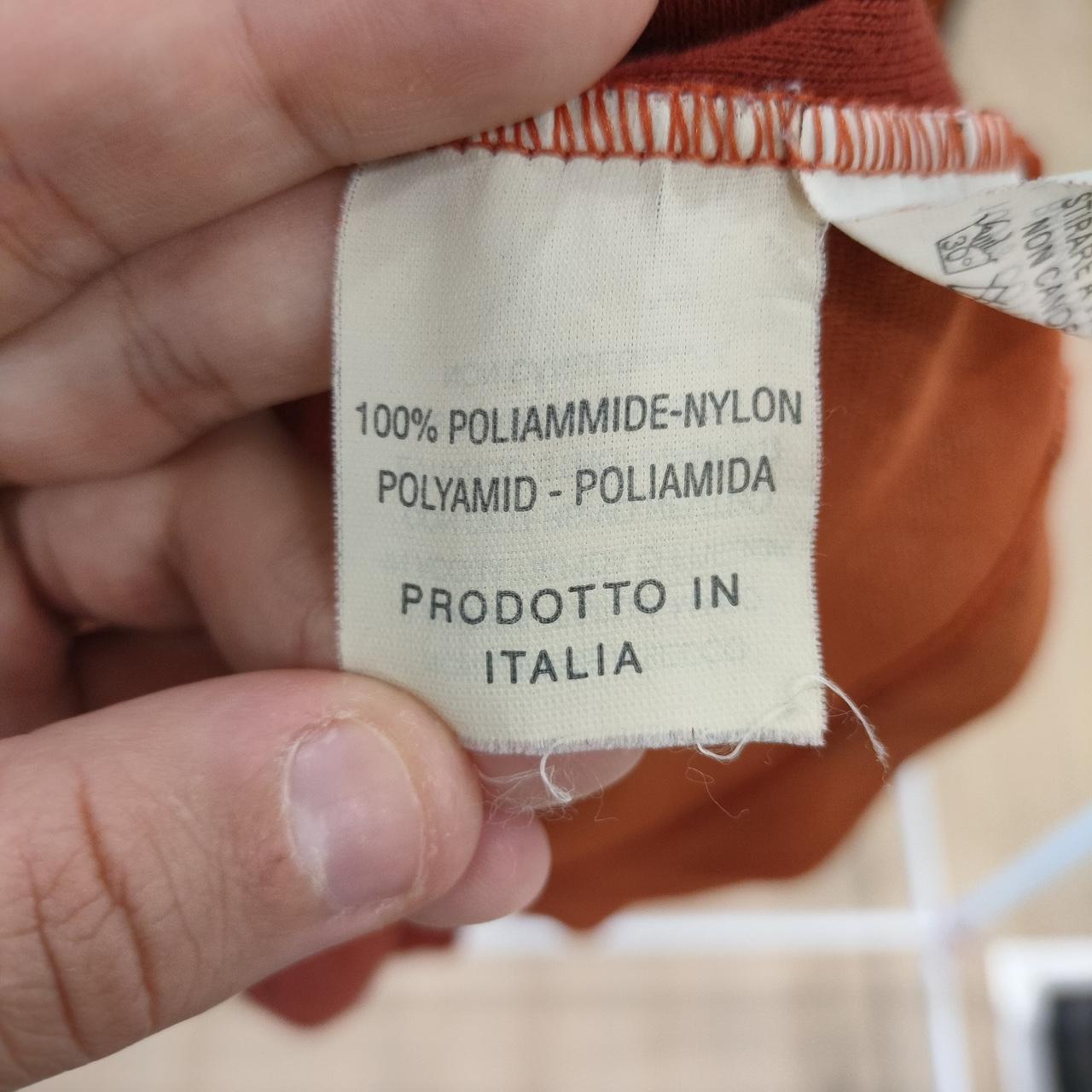 Clothing label with text on a garment held by a hand