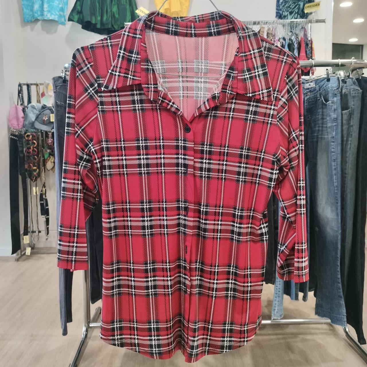 Red plaid long-sleeve button-up shirt hanging in a sustainable fashion store