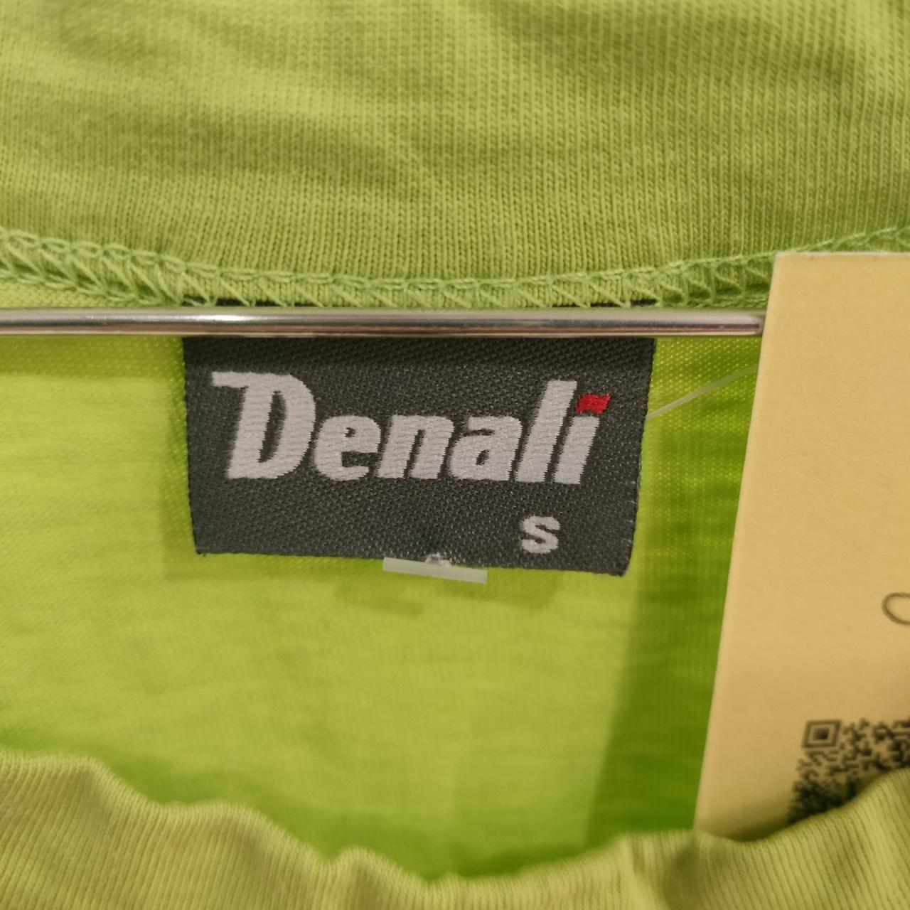 Close-up of Denali brand label on green sustainable fashion shirt, size small