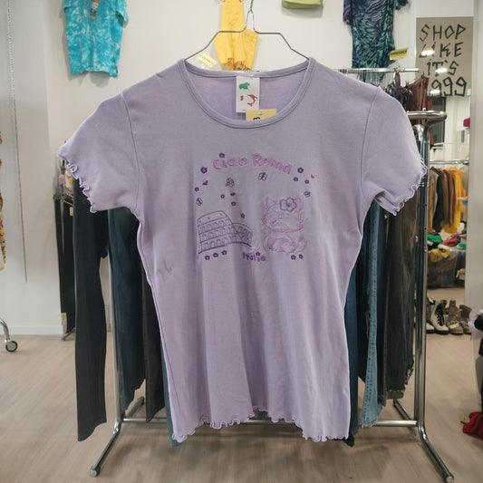 Light purple graphic t-shirt with Ciao Roma Italy cat and Colosseum design, displayed in a second hand clothing store.