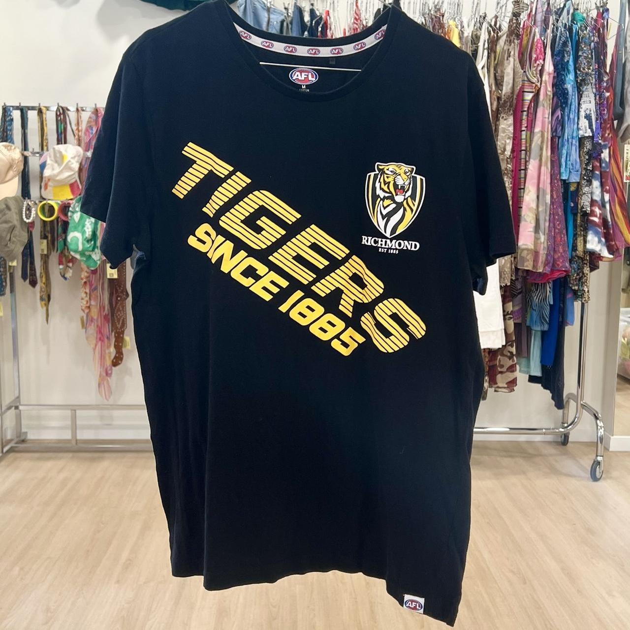 Black t-shirt with yellow text and logo on a rack in a store