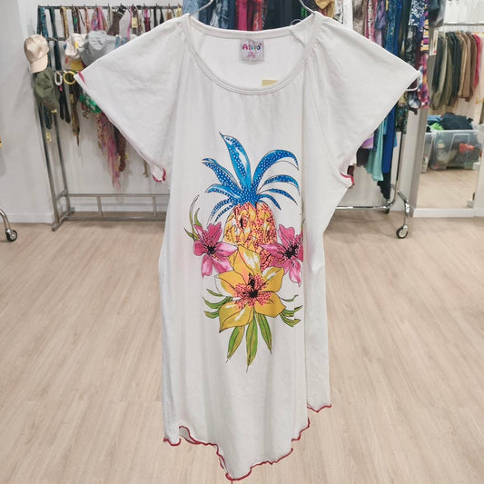 White dress with pineapple and tropical flower print, displayed in a clothing store.
