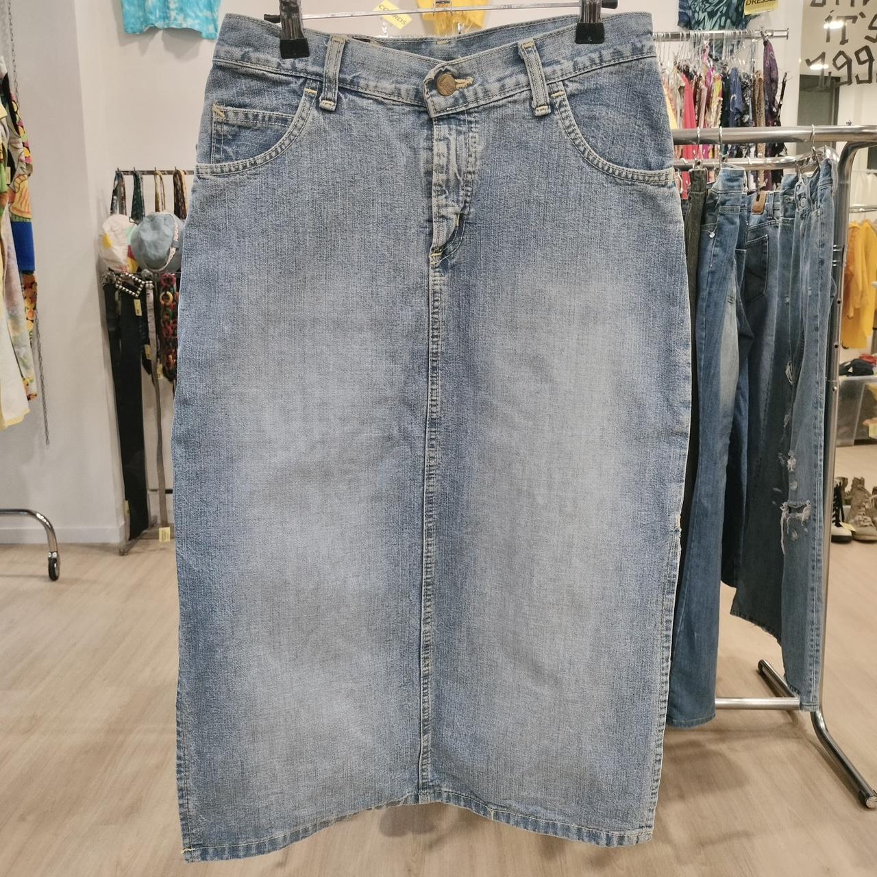 Blue denim skirt on a hanger in a store setting