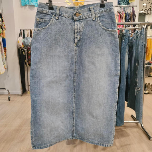 Blue denim skirt on a hanger in a store setting