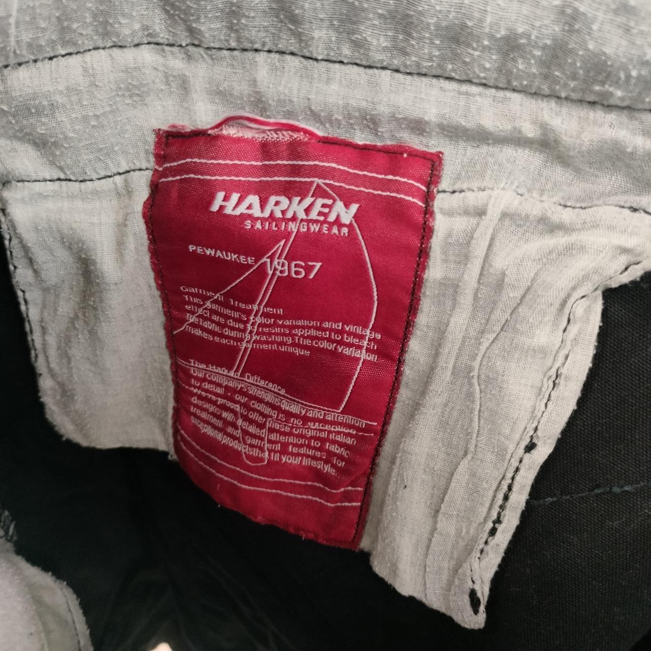 Harken Sailingwear red clothing label on light grey fabric, second hand sustainable fashion