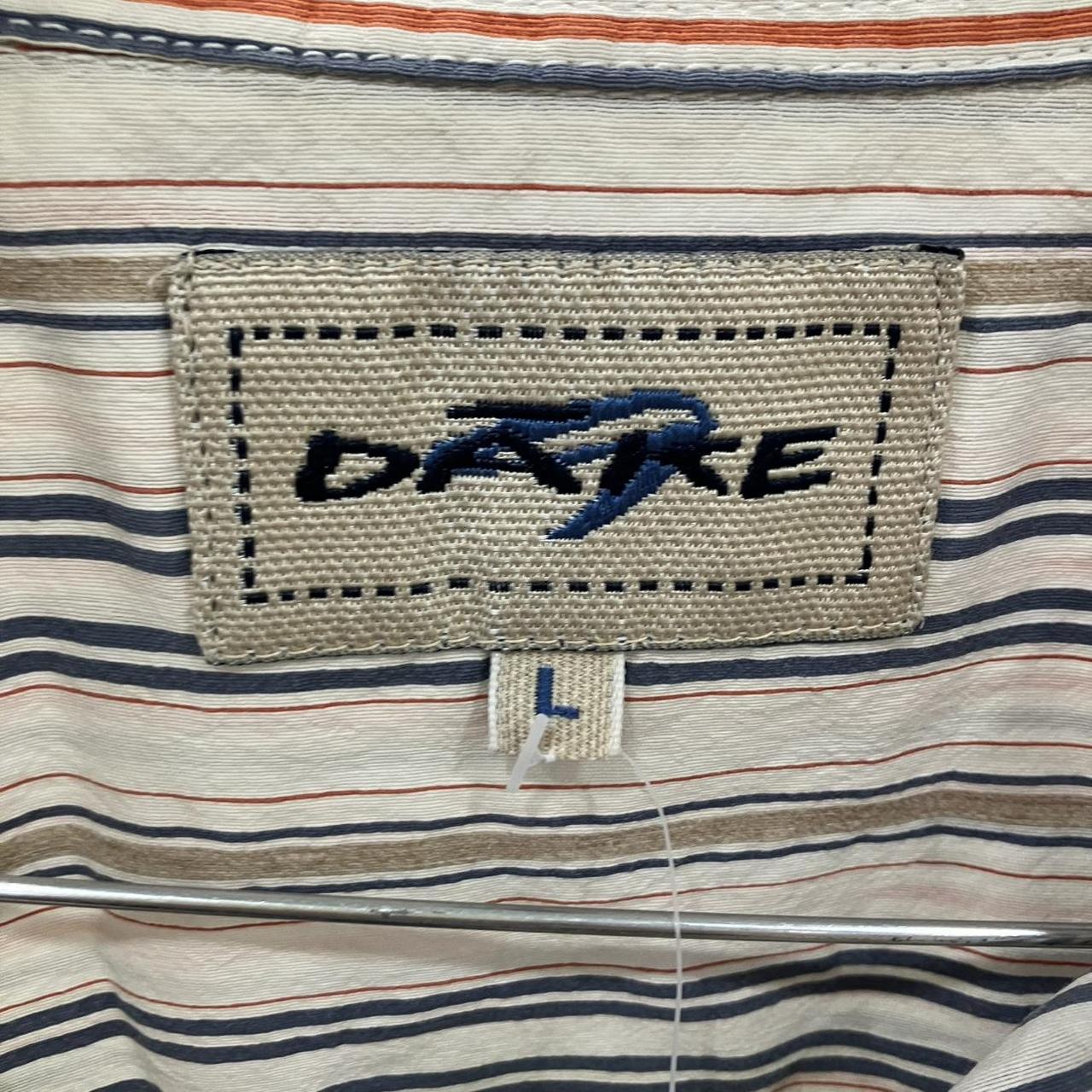 Close-up of a striped shirt with a 'Dare' label on a white background