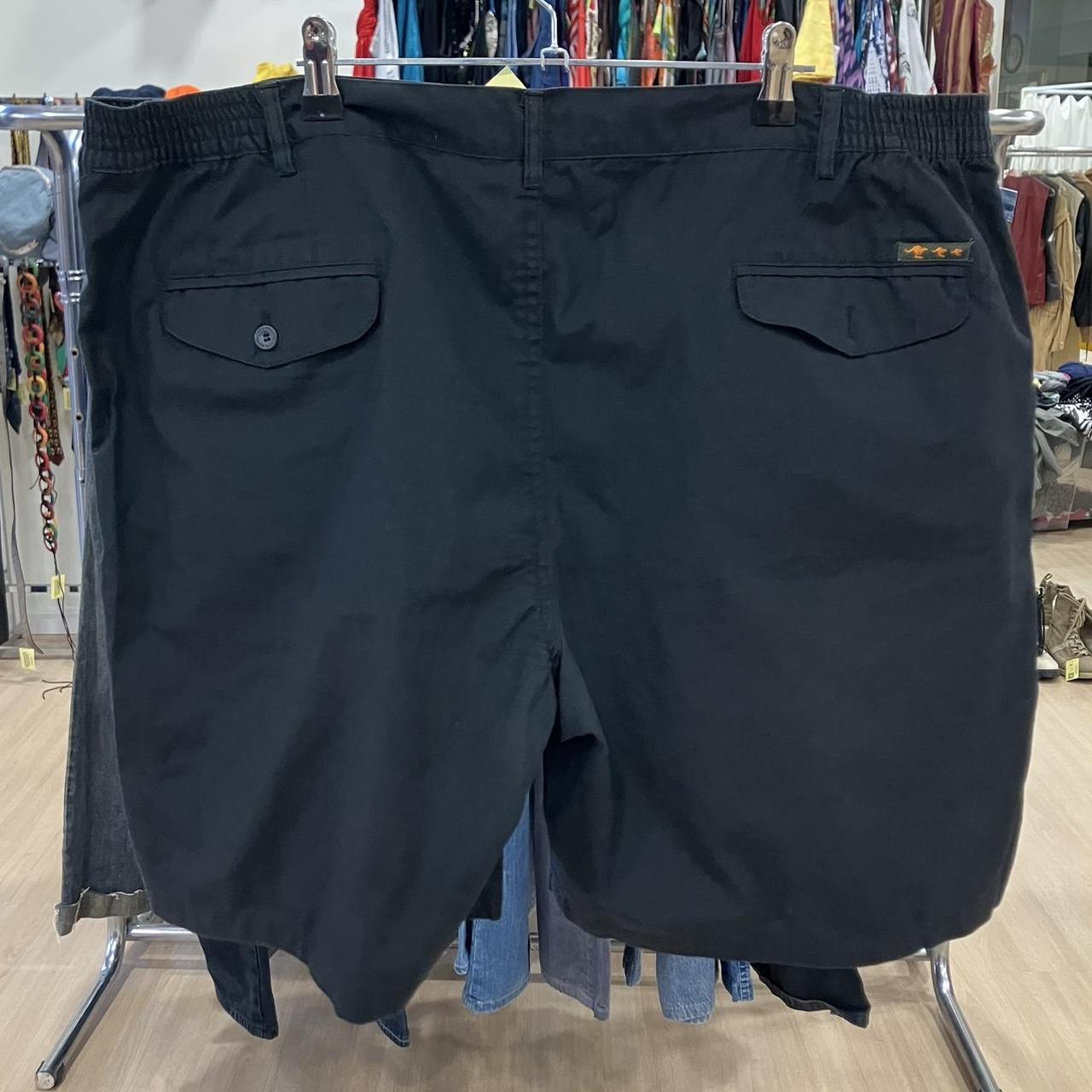 Black shorts hanging on a rack in a store setting