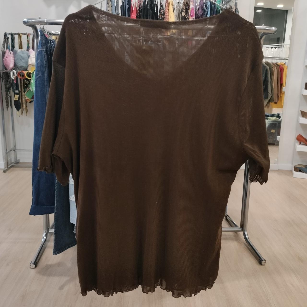 Brown sheer knit top with short sleeves on clothing rack in boutique store